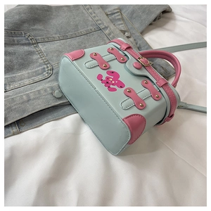 Detail of blue box crossbody bag with pink leather trim and cartoon rabbit print