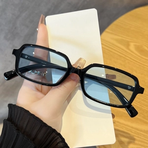 Detail showing vintage black rectangular frames with light blue lenses and smooth finish