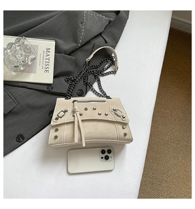 Top view of beige studded crossbody bag showing internal capacity with a smartphone