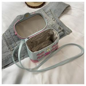 Detail view of mint green box bag with pink rabbit and chevron lining interior