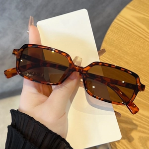 Detail of tortoise shell retro square sunglasses with brown lenses and side logo