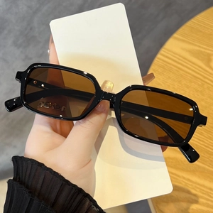 Detail view of square black plastic sunglasses frame with brown gradient resin lenses