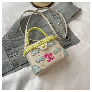 Close-up of mini box bag with neon handle, blue corners, and pink rabbit print detail