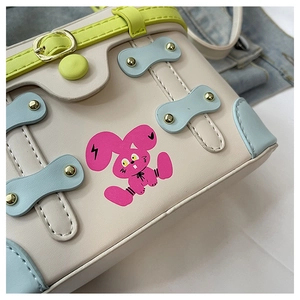 Close-up of contrast color box bag with pink graffiti rabbit and metal rivets details