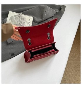 Detail view of the deep red chain bag interior showing zip pocket and magnetic closure