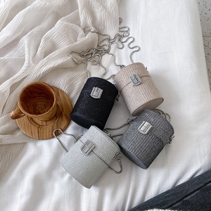Mini cylinder bags in black, silver, and champagne with glitter texture and chain straps