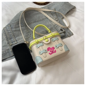 Detail view of mini contrast box bag showing cartoon rabbit and size compared to phone