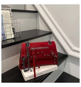 Detail of red punk motorcycle bag featuring silver rivets and gunmetal chain strap