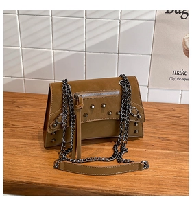 Detailed shot of brown vintage biker bag with silver rivets and metal chain strap
