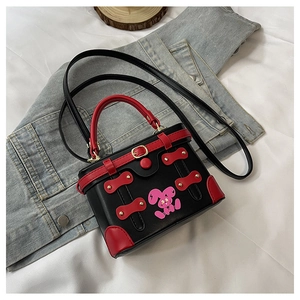 Close-up of black and red box bag with rabbit print on blue denim jacket background