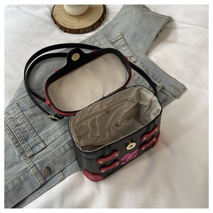 Detail of internal compartment and pink rabbit print on black crossbody box bag