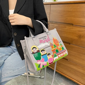Grey tote bag with Russian colorful embroidery shown on model with shoulder strap