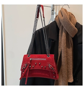 Detail of red biker bag featuring silver rivets, zipper tassels, and metal chain strap