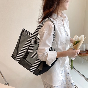 Minimalist black mesh tote bag with stylish black and white striped straps on a model