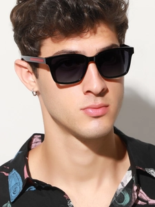 Male model wearing square polarized sunglasses with red detail on temples and grey lenses