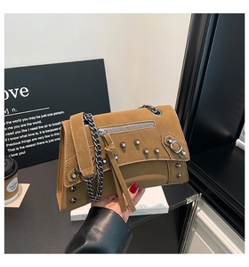 Detail of khaki motorcycle bag featuring silver rivets and metal chain shoulder strap
