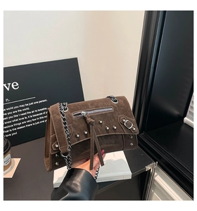 Detail of vintage dark brown frosted leather texture and punk chain on crossbody bag
