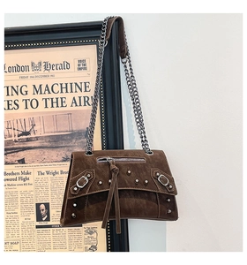 Detail of vintage brown suede crossbody bag with silver rivets and metallic chain