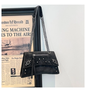 Detail of black punk shoulder bag with silver studs and chunky metal chain strap