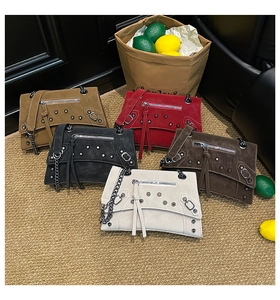 Flat lay of vintage rivet motorcycle bags in multiple colors with chain straps
