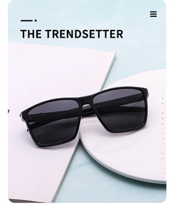 Detail view of black square polarized sunglasses on a modern marble surface