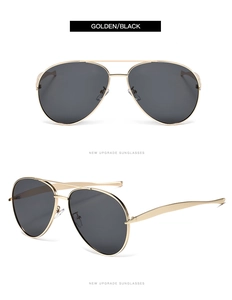 Detail view of golden aviator metal sunglasses with sleek double bridge and black lenses