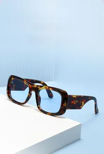 Macro shot of tortoiseshell frame sunglasses with blue lenses on a white display stand