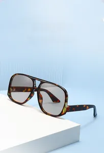 Detail of oversized pilot sunglasses featuring tortoise frame and gray gradient lenses
