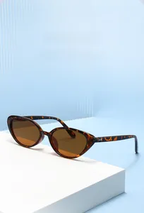 Dettaglio occhiali da sole cat-eye retrò con montatura tartarugata su supporto