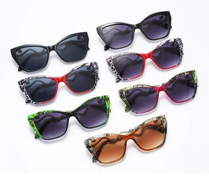 Flat lay of retro cat eye sunglasses with snake-pattern temples in seven assorted colors