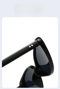 Dettaglio degli occhiali da sole cat-eye neri con rivetti metallici tondi argentati