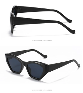 Detail view showing black thick frames and dark gray lenses of stylish cat-eye sunglasses