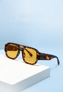 Close-up of retro square amber lenses and tortoiseshell frame on a modern platform