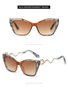 Detail of snake-shaped golden metal temples with red accents on cat-eye sunglasses