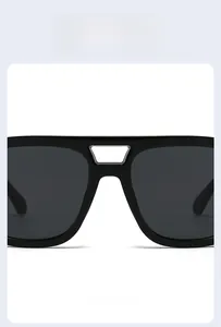 Detail of black oversized sunglasses showing the silver metal bridge and premium lenses