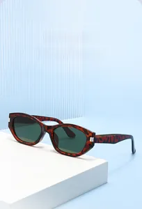 Close-up of tortoise shell frame sunglasses with dark green lenses and silver hinge detail