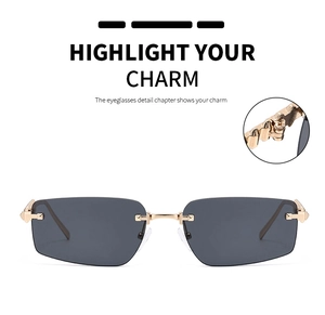 Detail of rimless rectangle sunglasses with gold metal bridge and sleek gray lenses