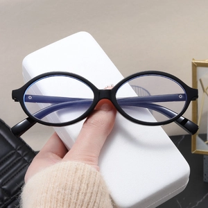 Detail of oval black frame blue light blocking glasses with a white textured leather case