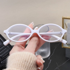 Detailed view of oval white eyeglass frames with smooth texture and metal screw hinges