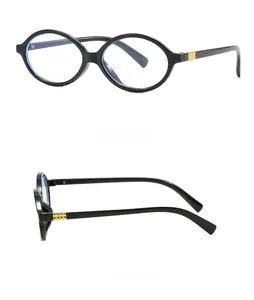 Detail view of oval black glasses frames featuring gold hinge accents and retro design