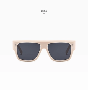 Detail of beige square frame sunglasses with dark grey lenses and metal rivet accents