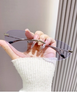 Détail de lunettes de soleil ovales sans monture avec verres violets et branches en métal