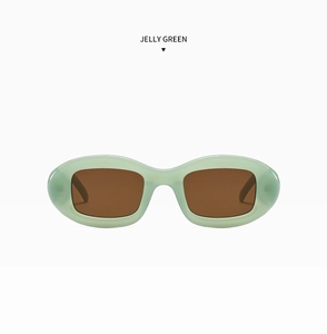 Vue de face de lunettes de soleil ovales vert gelée avec des verres marron clair