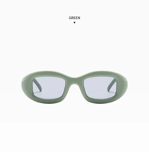 Détail de lunettes de soleil ovales vert avocat avec monture épaisse et verres gris