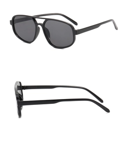 Détail de lunettes de soleil aviateur rétro avec monture noire à double pont et verres noirs