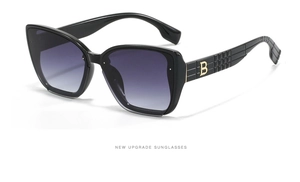 Detailed close-up of gradient purple lenses and golden B-logo on black sunglasses