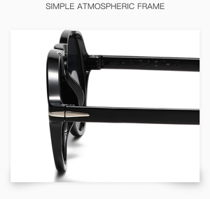 Detailed macro view of black resin sunglasses side frame with silver arrow metal hinge