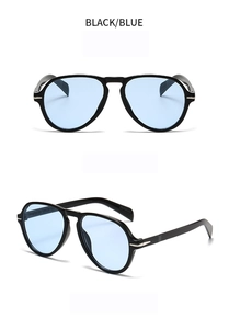 Close-up of oversized aviator sunglasses featuring black frames and light blue lenses
