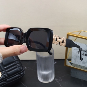 Detailed close-up of golden metal hinge decoration on luxury black square sunglasses