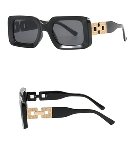Macro detail of rectangle sunglasses showing a gold chain link hinge with H-shaped metal accent